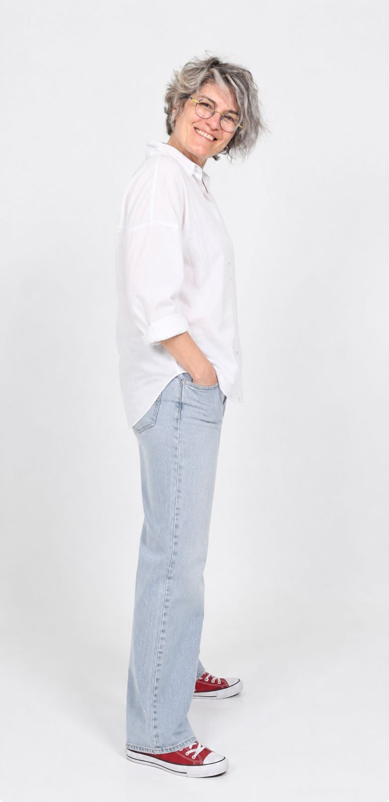 Doress Naffaa smiling in a white shirt and jeans